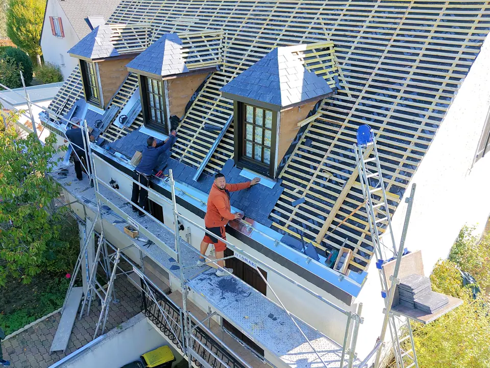 Rénovation de couverture en ardoise et travail depuis un échafaudage