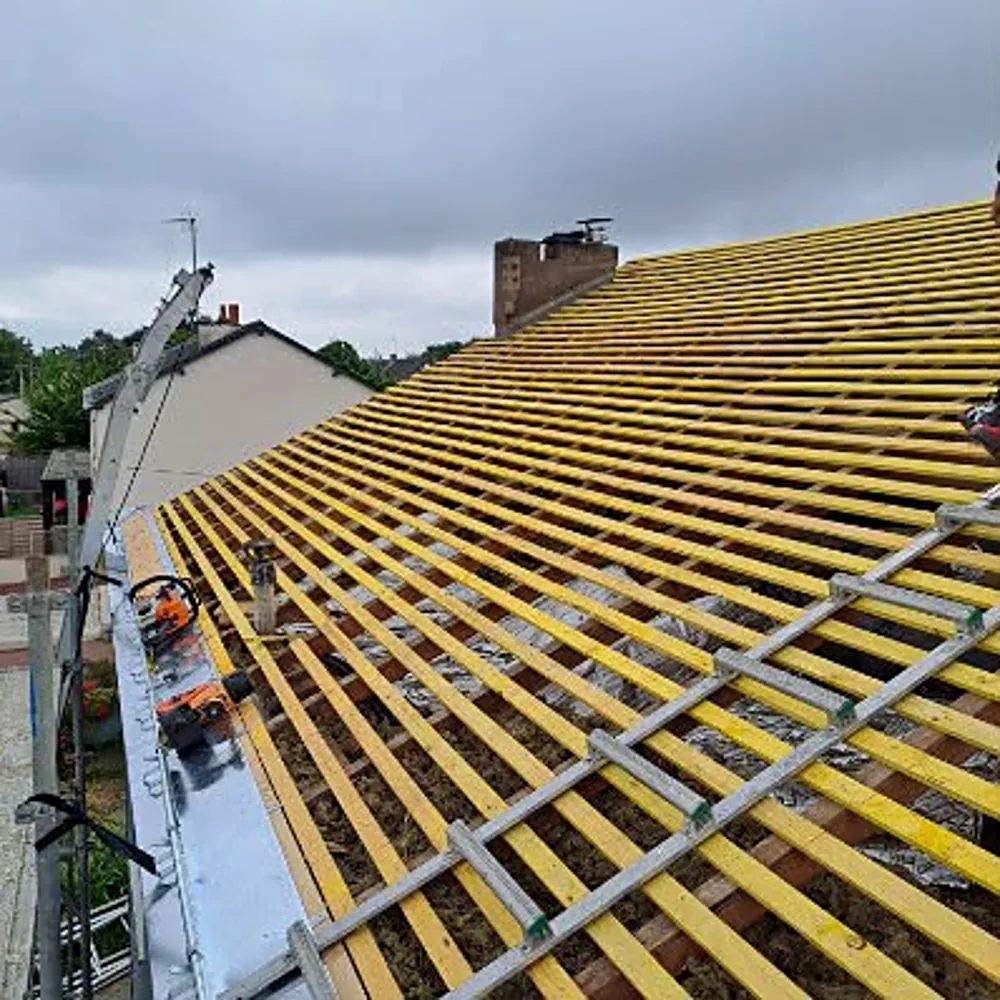 Pose de liteaux sur une toiture pendant des travaux de couverture
